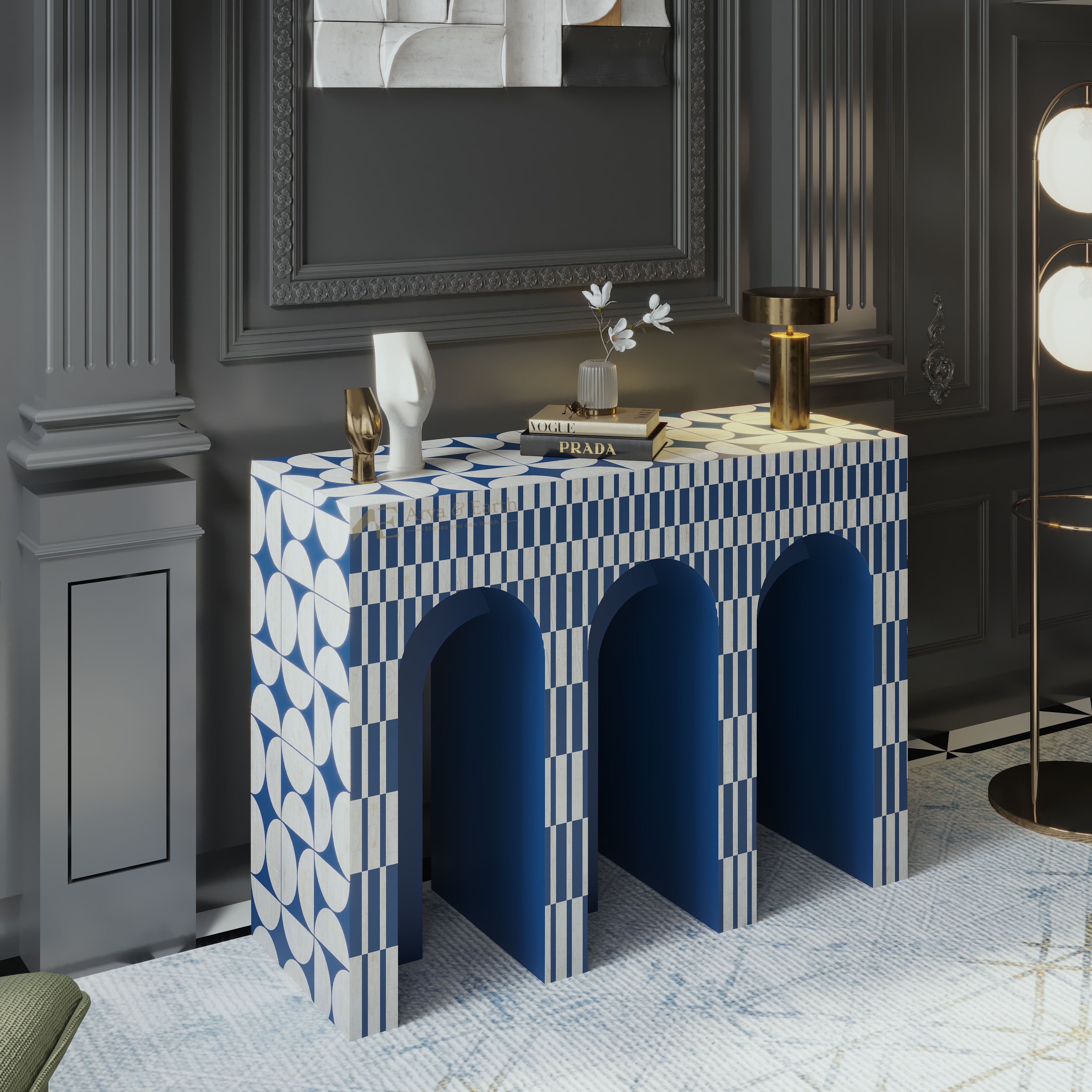 A decorative console table with a blue and white geometric pattern, featuring three arched openings underneath, styled in a dark gray room with gold and white decor.