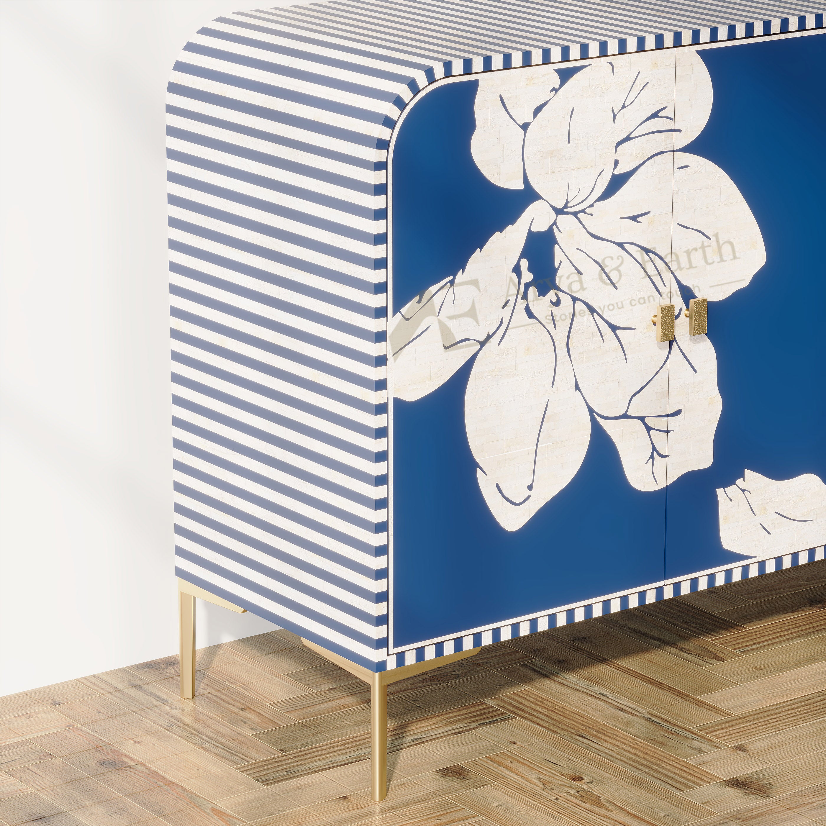 A modern sideboard cabinet with a blue and white striped pattern on the side, a large white floral print on the front, and gold metal legs, shown in a room setting on a wood parquet floor.