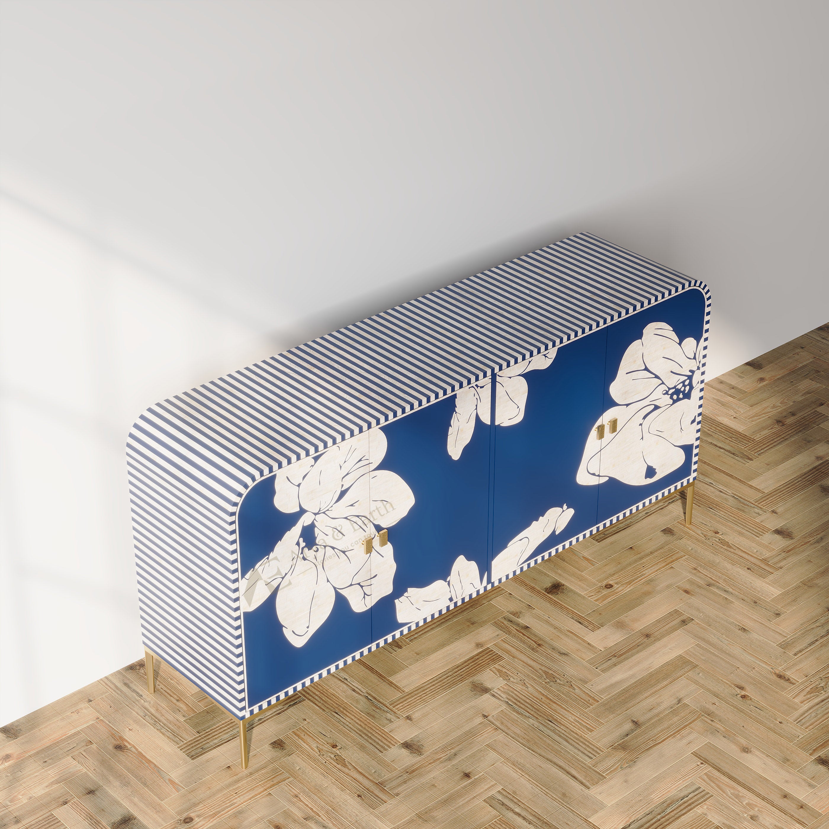 A modern sideboard cabinet with a blue and white striped top, white floral motifs on a blue front, and gold legs, shown in a room with a light gray wall and herringbone wood floor.