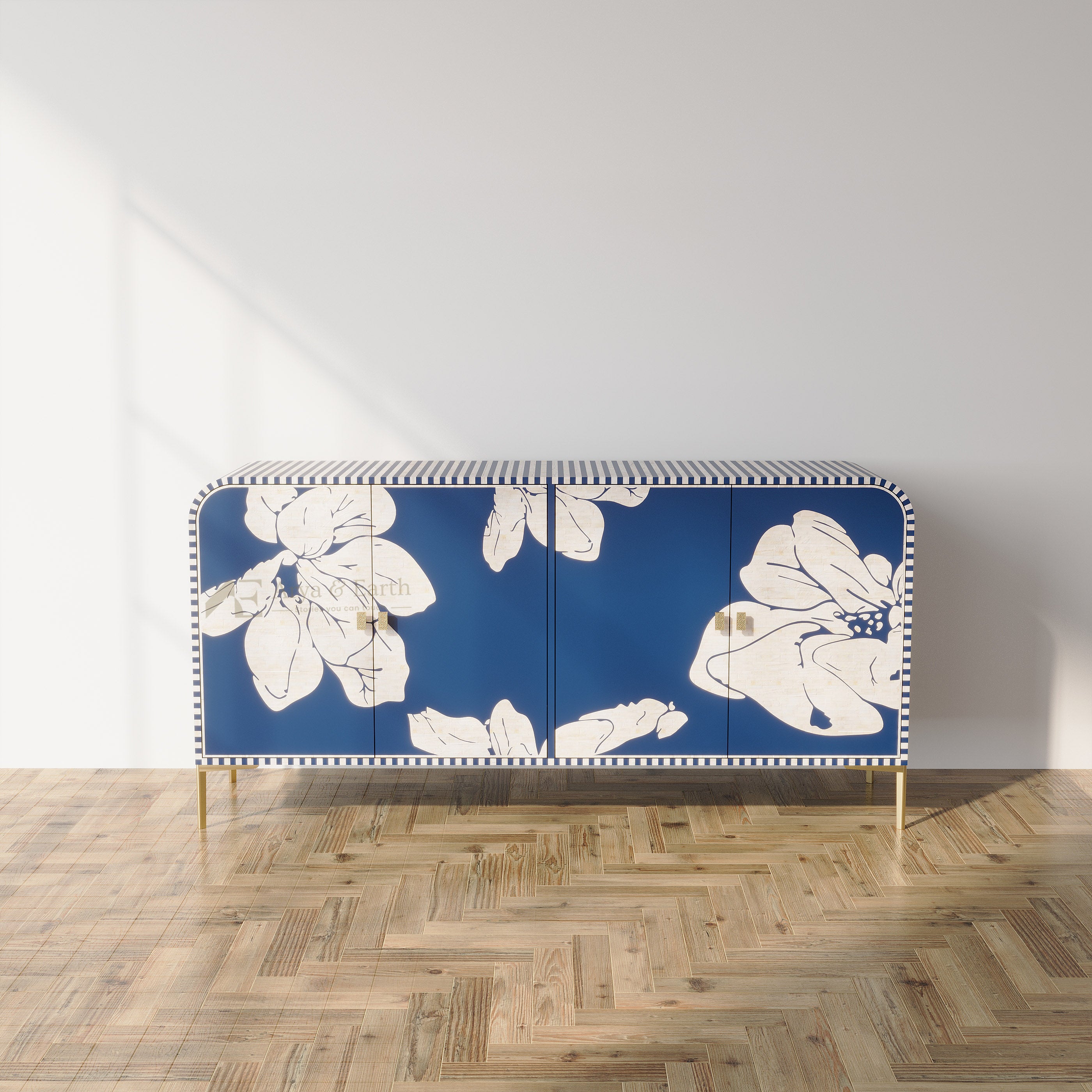 A mid-century modern sideboard cabinet with a navy blue background and large white floral motifs, supported by slim gold legs, set against a minimalist white wall and light wood herringbone parquet flooring.
