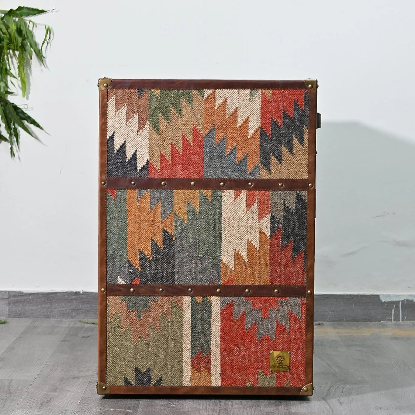 Vintage-style trunk with geometric pattern on a gray floor.
