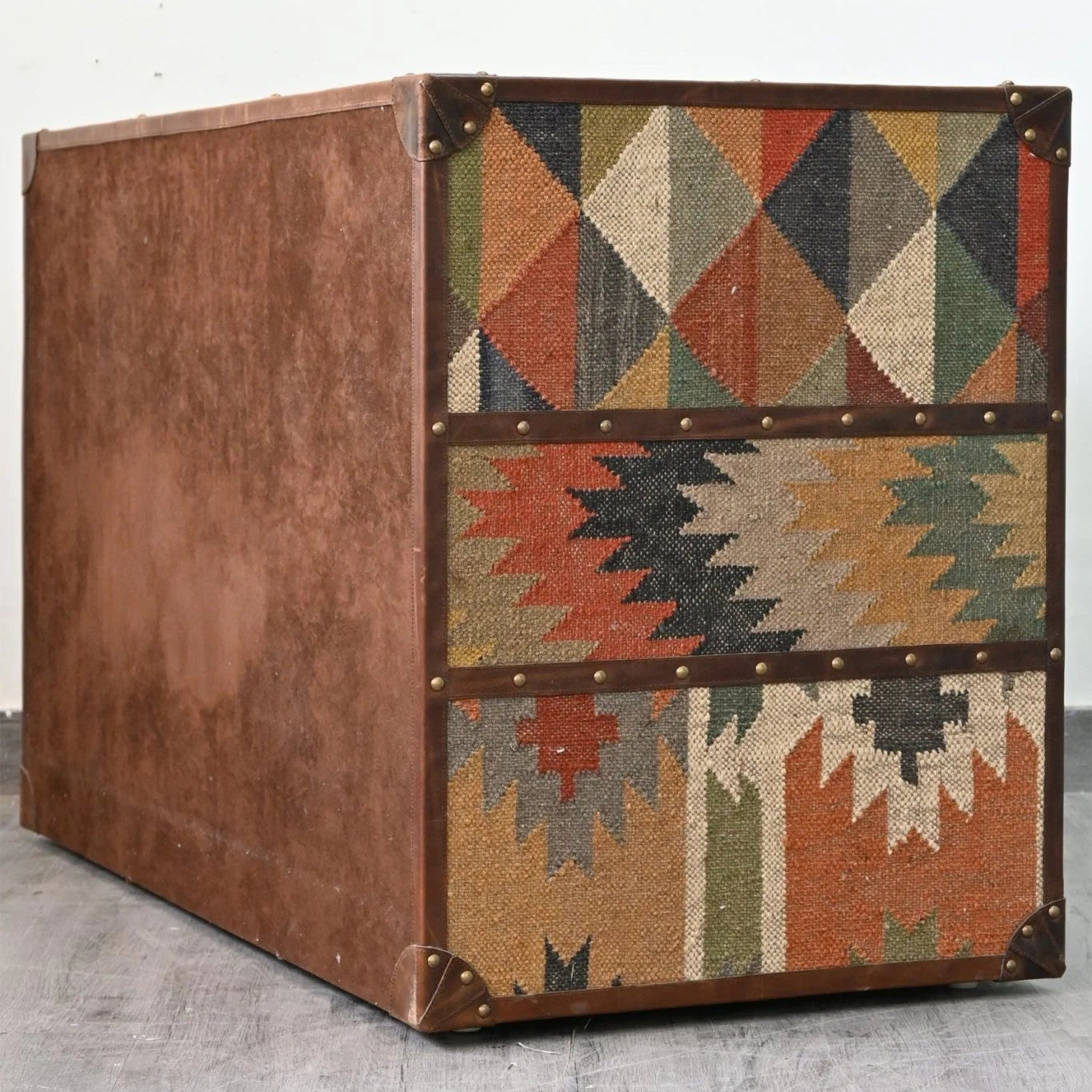 Decorative storage box with geometric pattern on a light gray floor