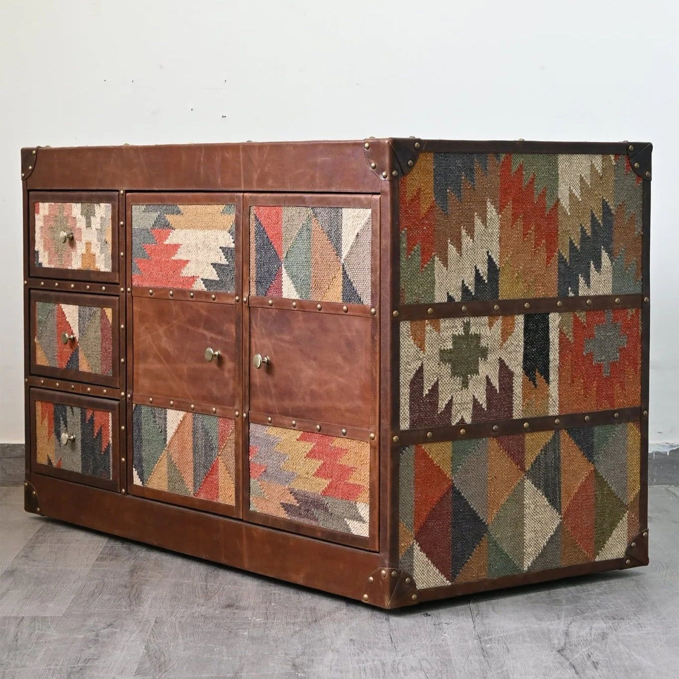 Multicolored geometric-patterned chest on a gray floor with a white wall background