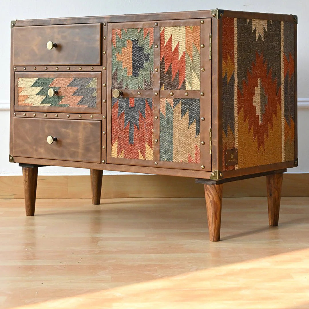 Wooden sideboard with patterned doors and drawers on a wooden floor.