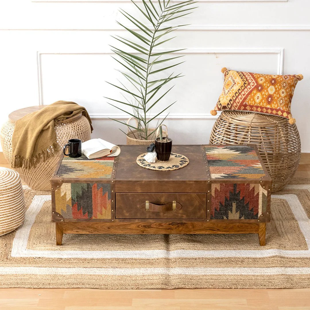 Living room with a wooden coffee table, wicker chairs, and decorative pillows.