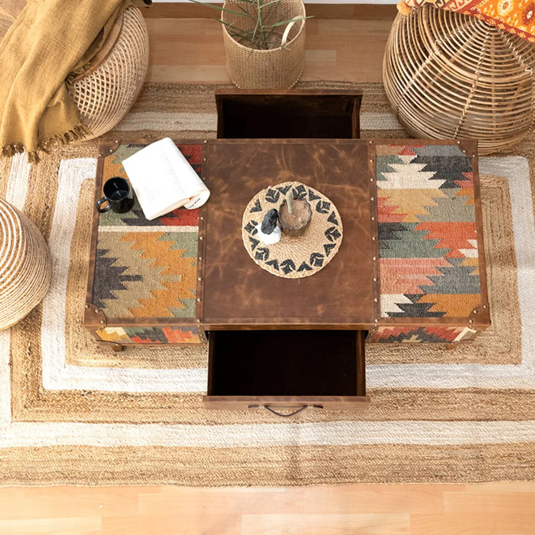 Decorative coffee table with a plant, books, and decorative items on a wooden floor.
