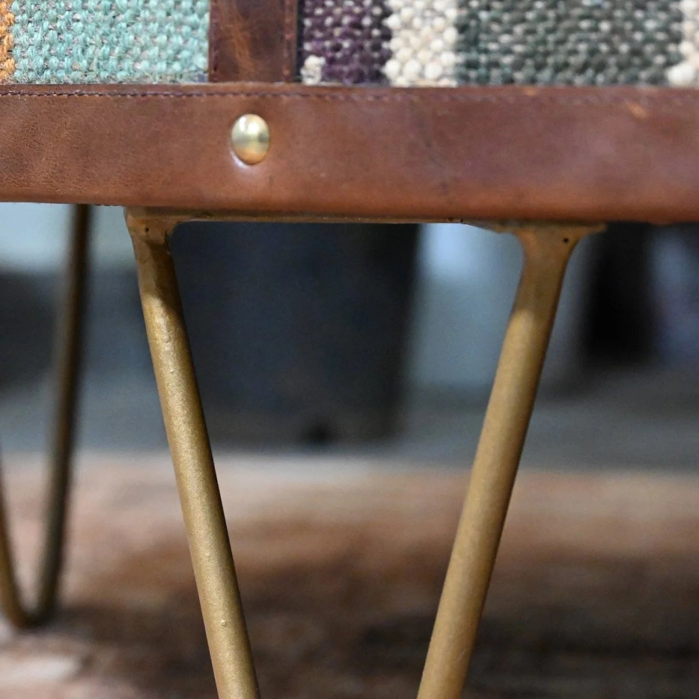 Close-up of a coffee table leg with a woven seat and blurred background