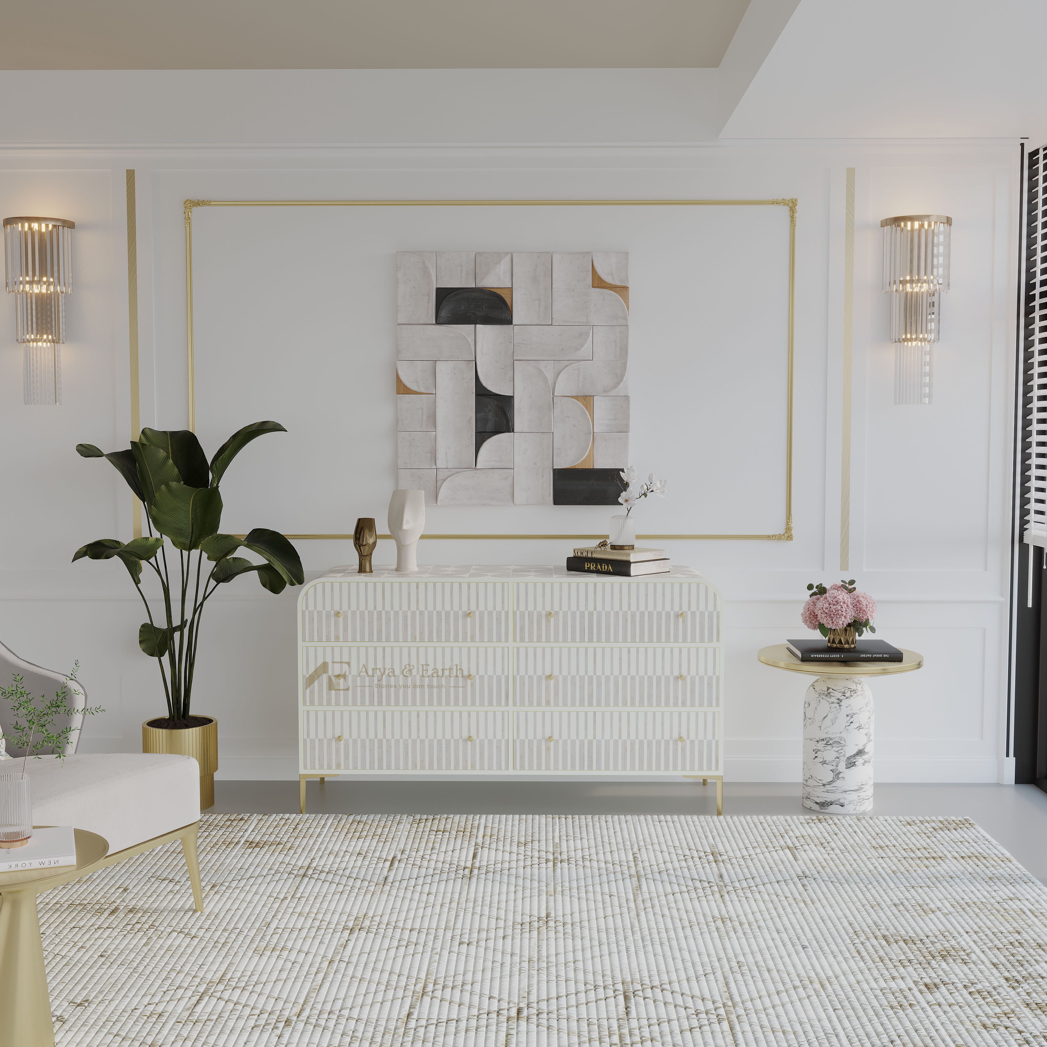 A styled interior room featuring a white ribbed chest of drawers with gold legs, a large abstract geometric wall art piece in white, black, and gold, a gold-framed wall border, two crystal sconces, a potted green plant, and a patterned rug.