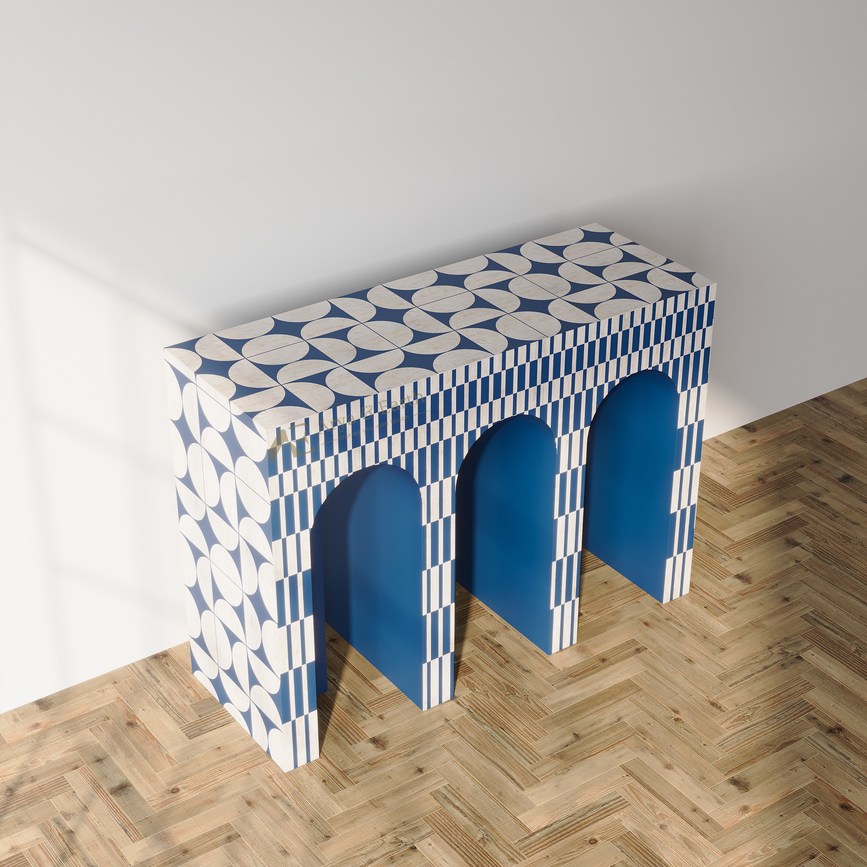 A modern console table with three arches, featuring a bold blue and white geometric pattern on the top and sides, set against a minimalist white wall and light wood herringbone floor.