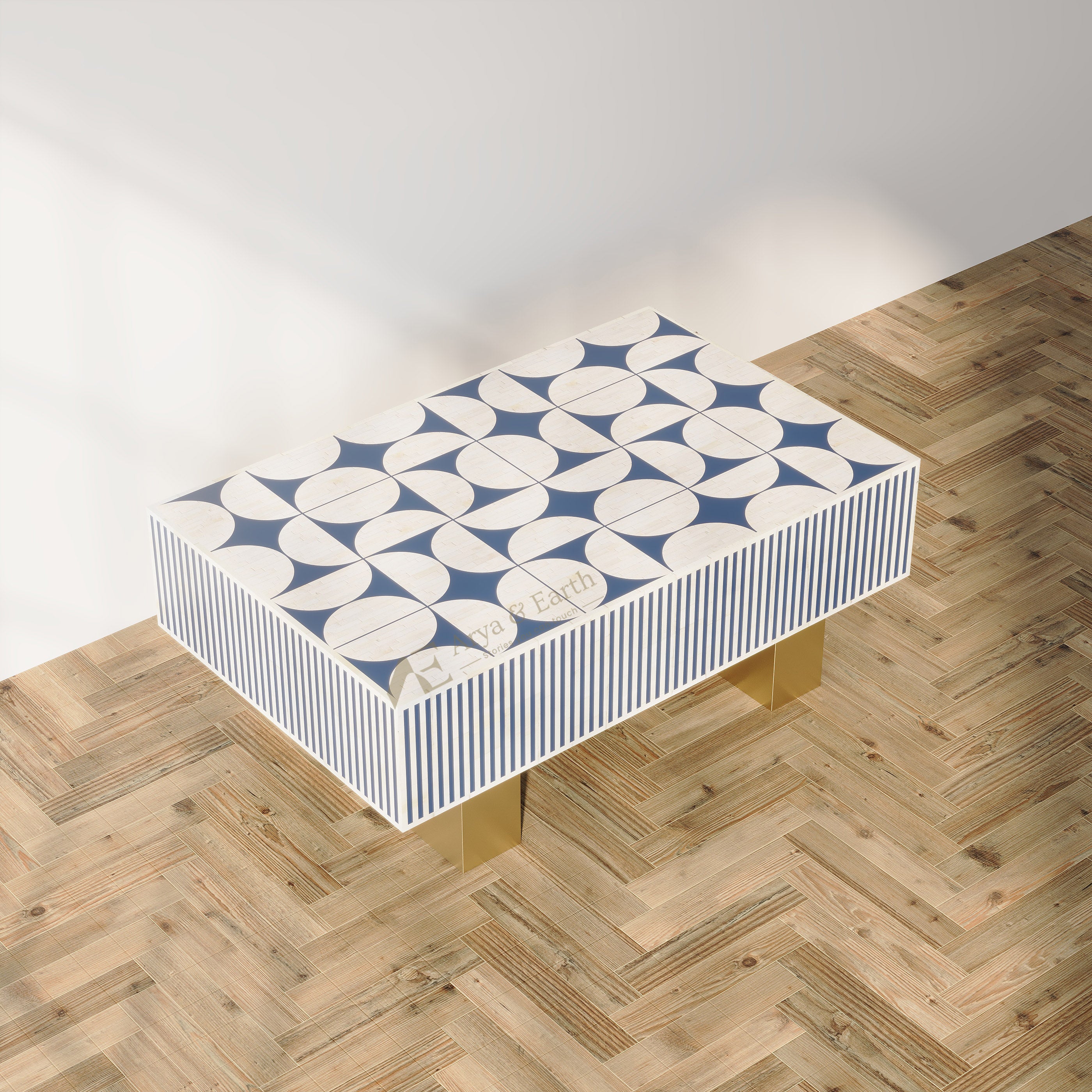 A rectangular accent table with a blue and white geometric pattern on the top and striped sides, supported by gold legs, set on a light wood herringbone floor against a white wall.