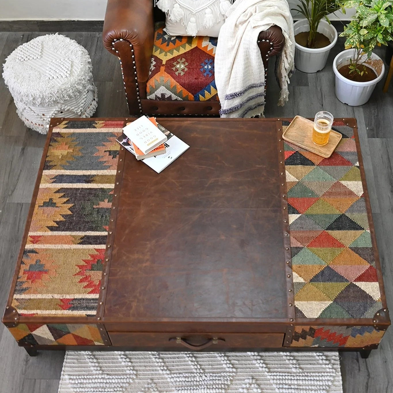 Brown leather coffee table with patterned kilm work and leather in a living room setting.