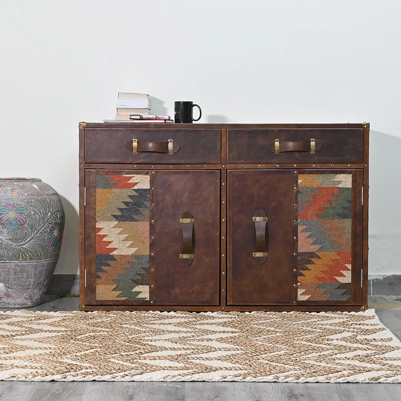 Wooden sideboard with patterned doors on a gray floor and white wall