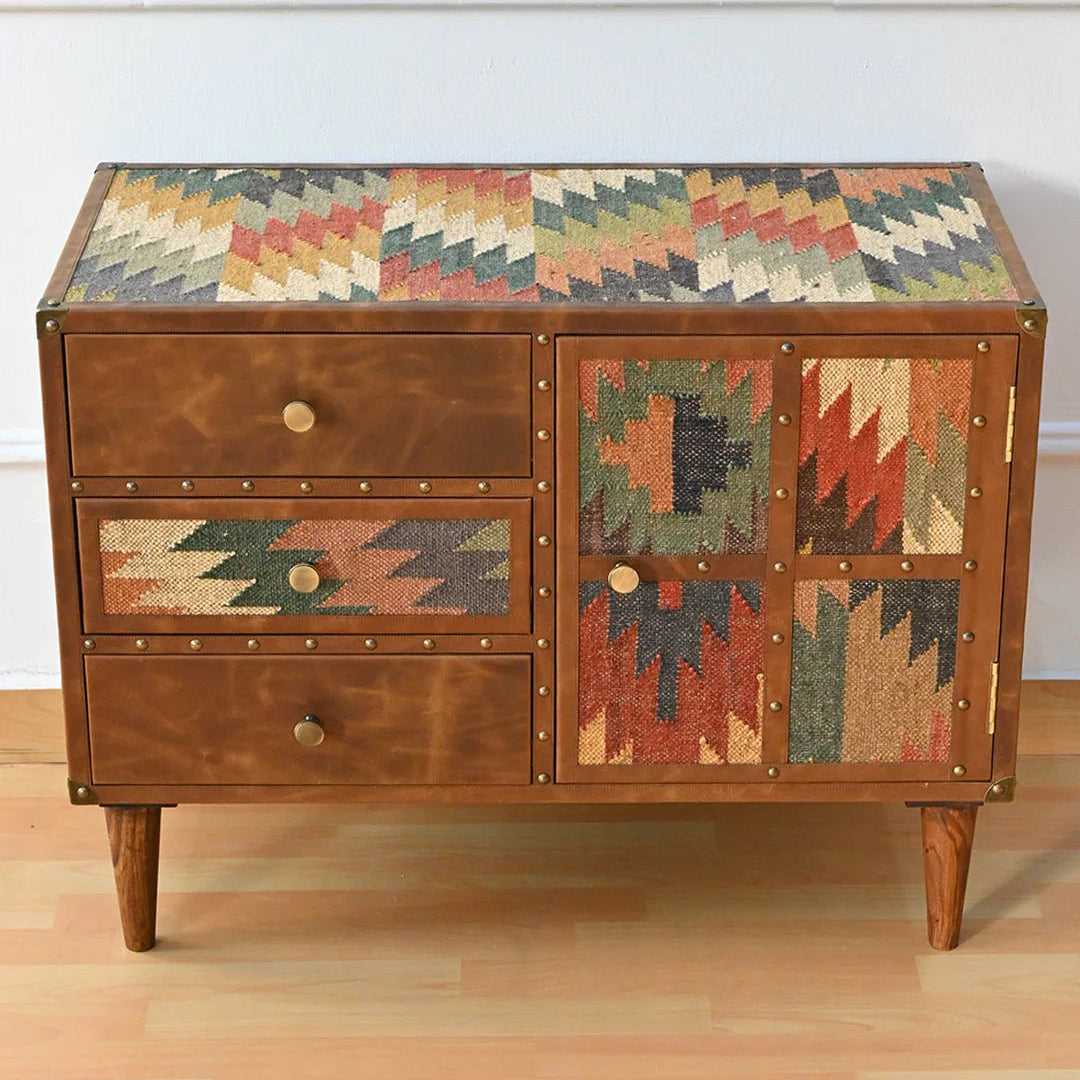 Wooden chest with geometric patterned top and side panels on a wooden floor.