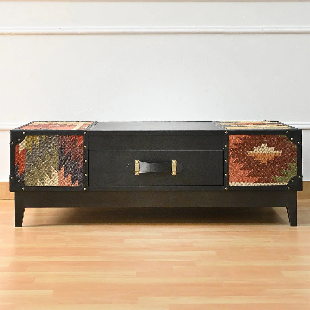 Black coffee table with patterned sides on a wooden floor