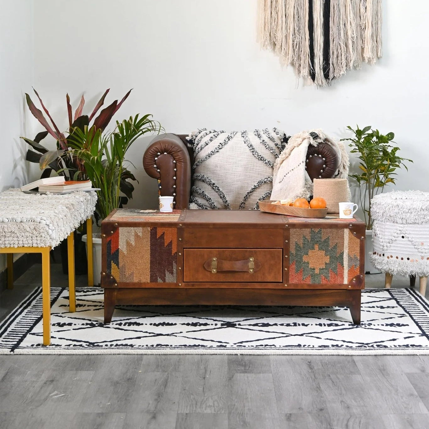 Living room with a patterned tapestry, wooden coffee table, and decorative items.