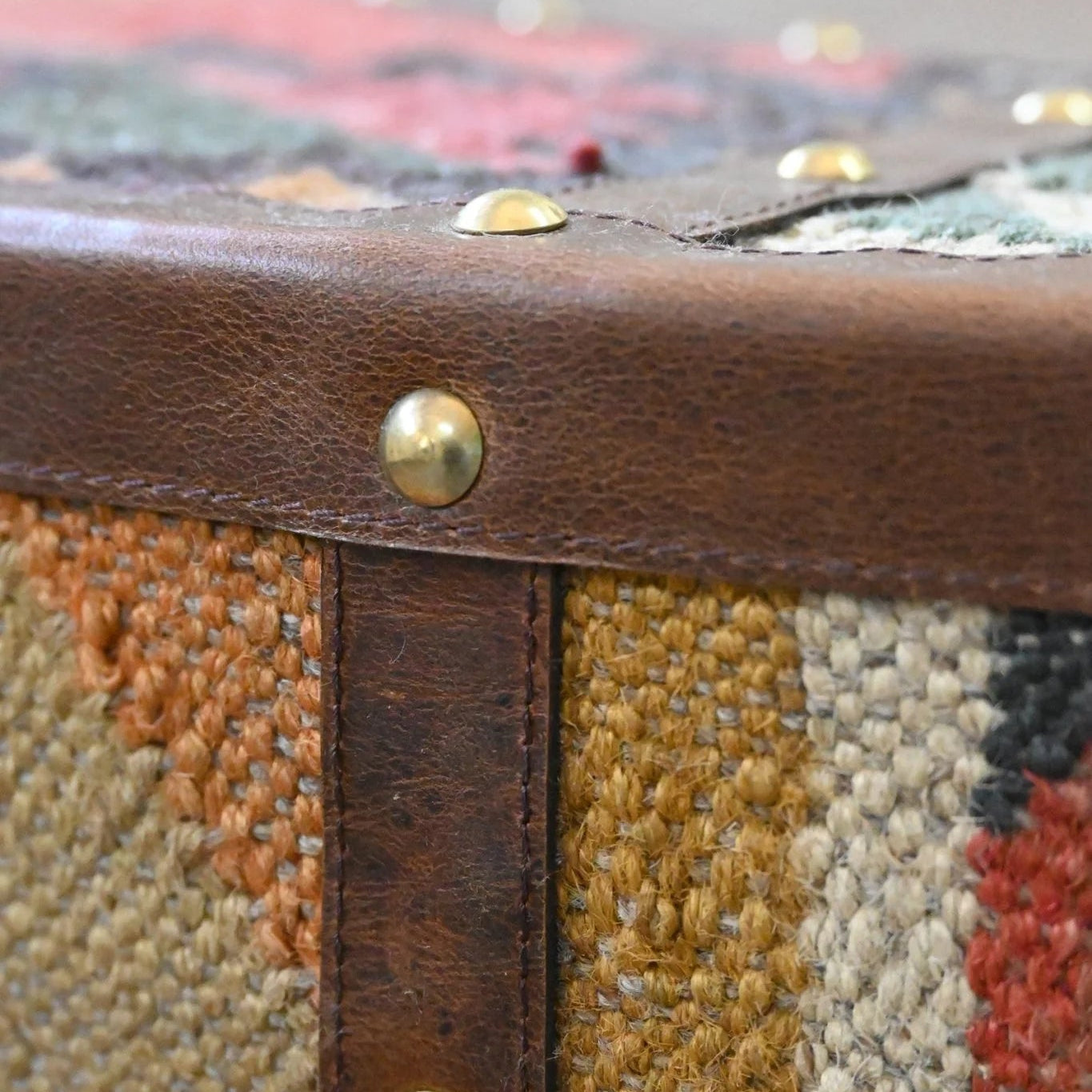 Close-up of a textured fabric surface with gold rivets