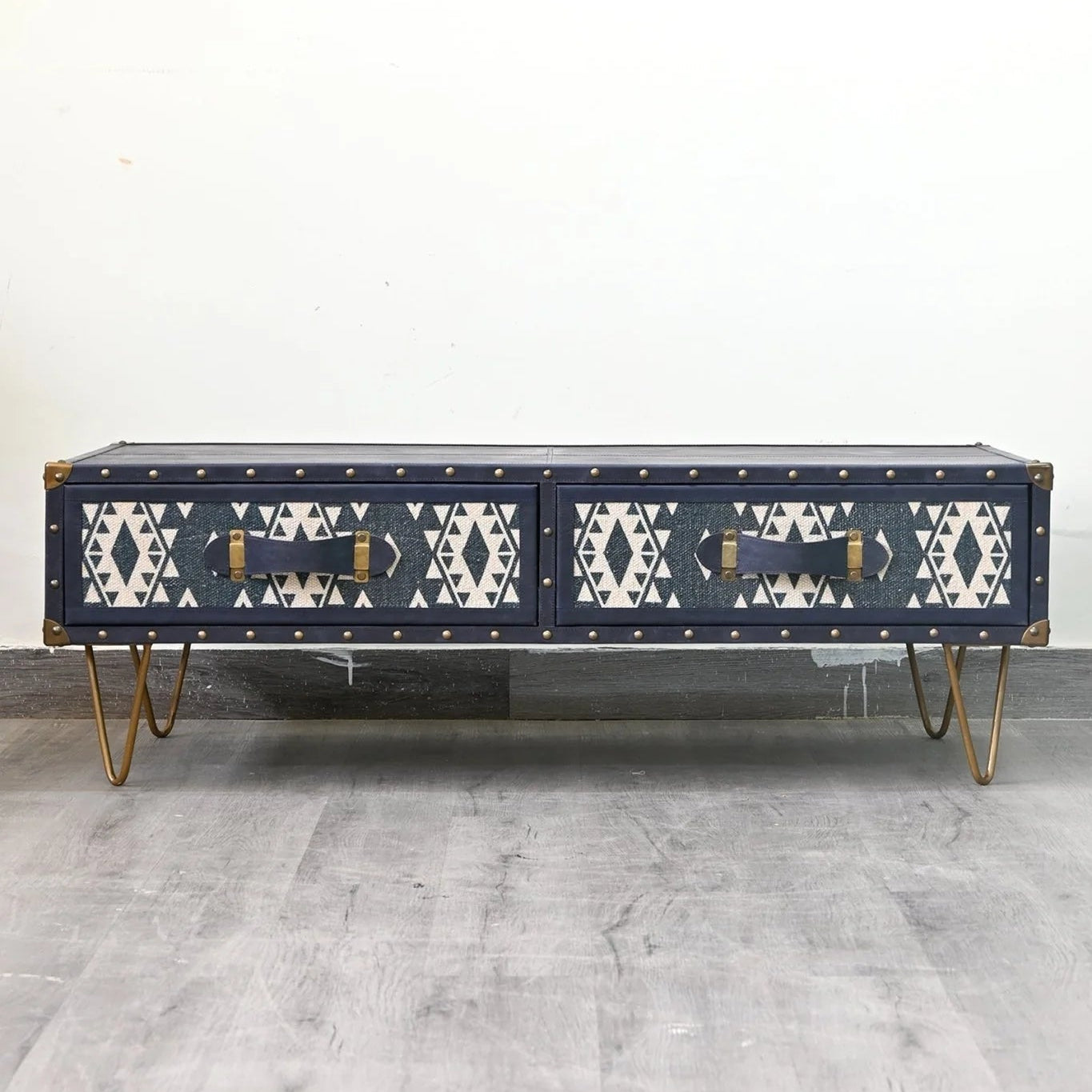 Navy blue coffee table with geometric pattern on a gray floor