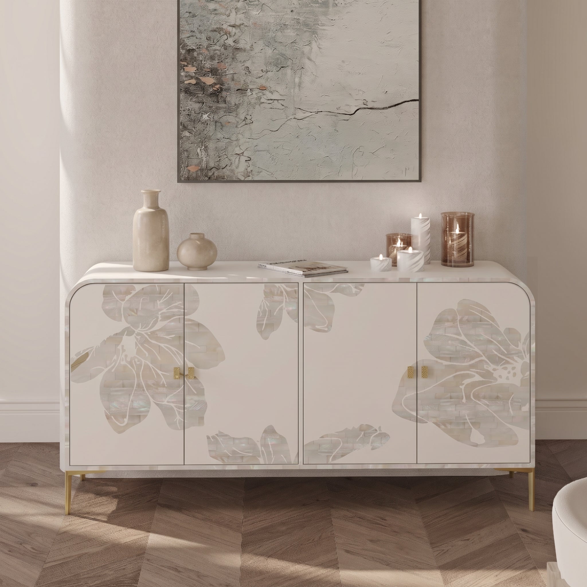 A modern sideboard cabinet with a white marble top and doors featuring large gray floral inlays, styled in a bright entryway with candles, vases, and a framed abstract print above.