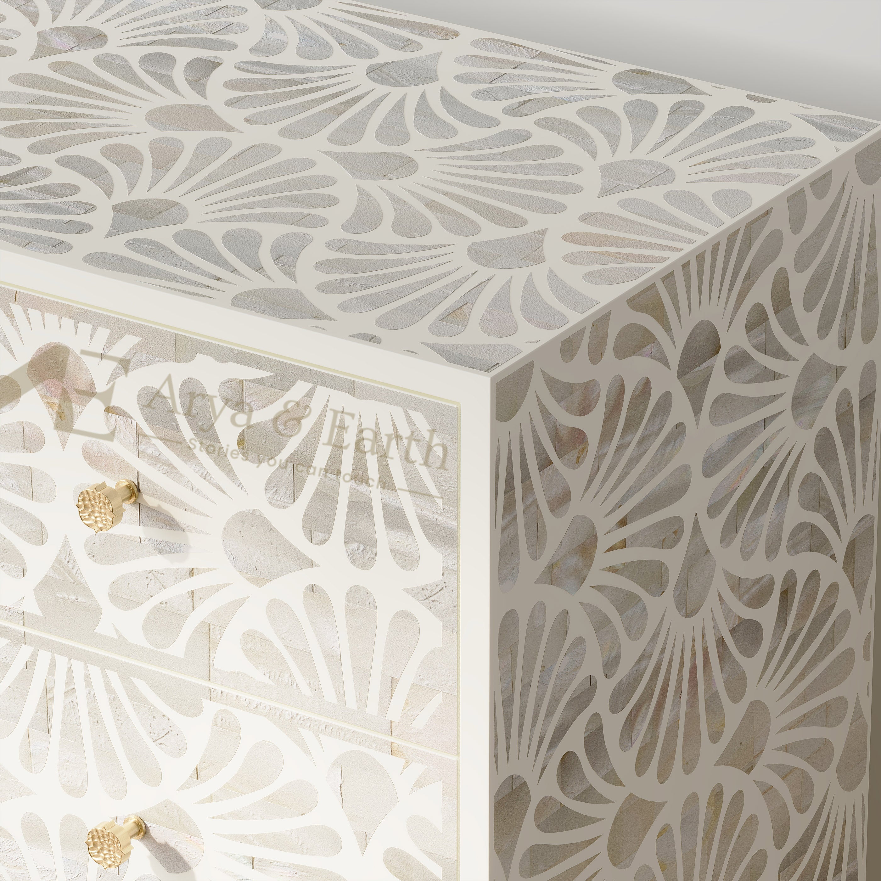 White carved wooden chest of drawers with a geometric fan-shaped cutout pattern, featuring gold knobs