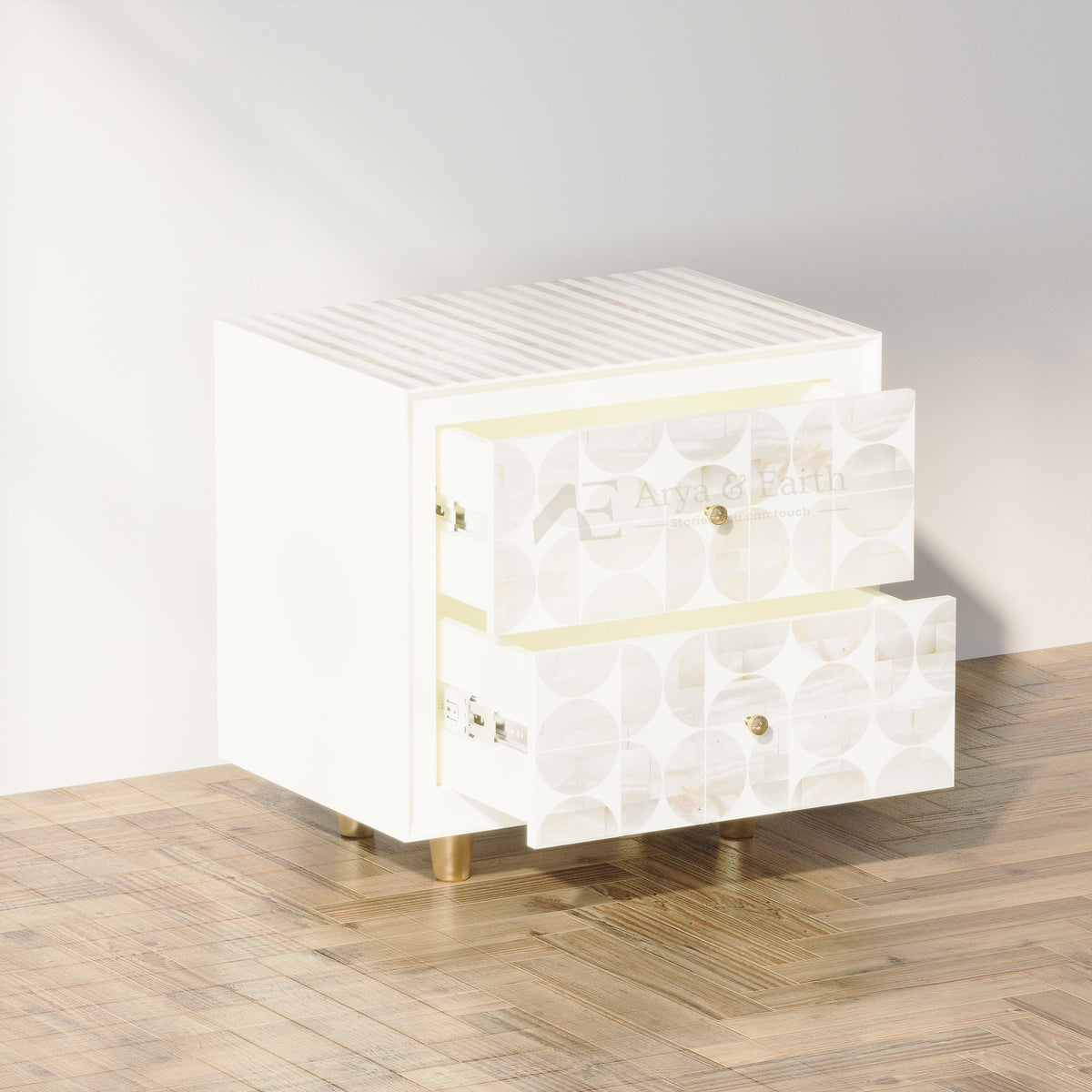 A modern two-drawer nightstand in glossy white with patterned drawer fronts, gold-tone knobs, and gold legs, shown on a wood floor against a light wall.