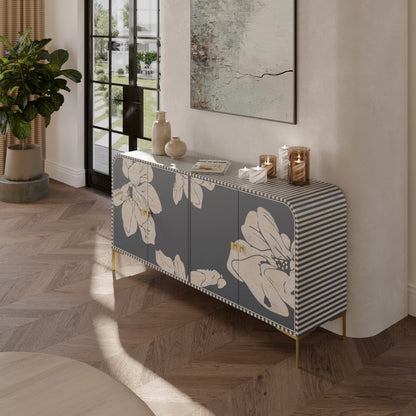 Mother of pearl inlay grey cabinet with floral and striped design in a room with plants and a painting.