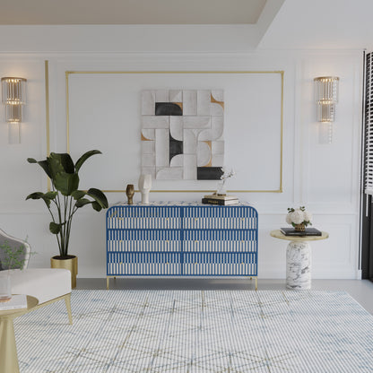 Modern living room with a blue and white striped chest of drawers, plant, and abstract art.